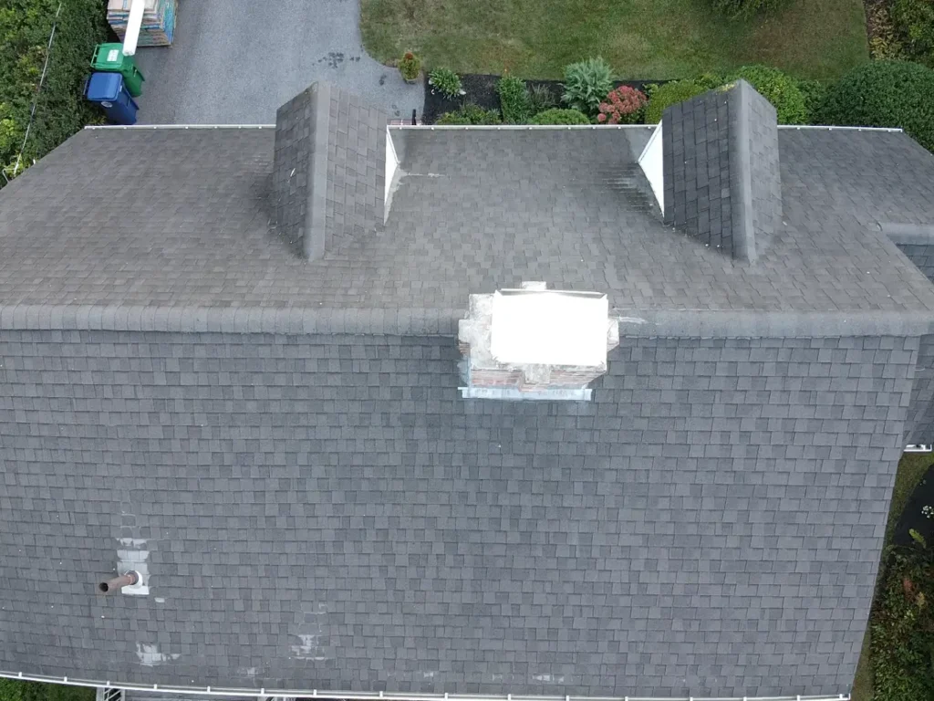 Top view of a newly repaired asphalt shingle roof with clean lines and even surface texture.