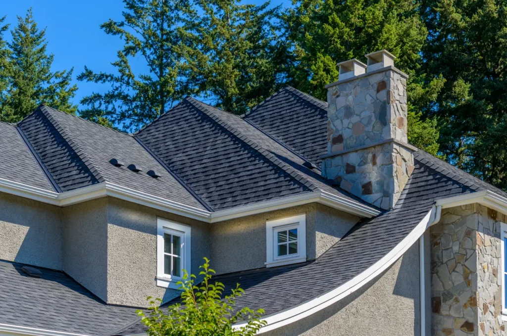 Residential roof and chimney showing roof areas that may need urgent roof repair Boston service after storm damage inspection. 