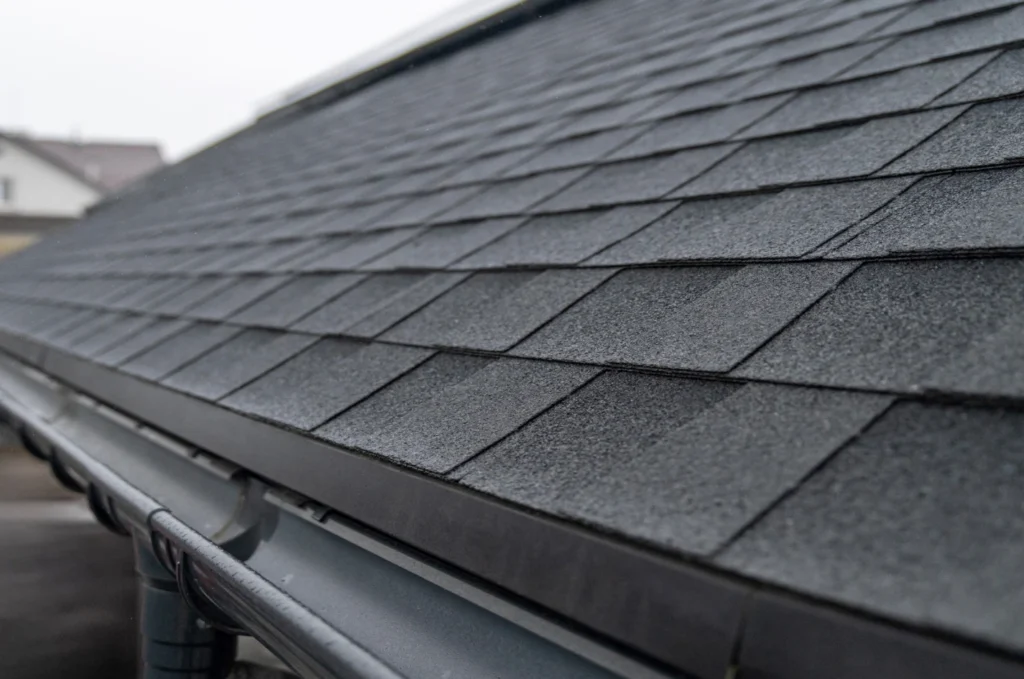 Close-up view of asphalt shingles and gutters on a home, showing materials commonly inspected during a roof repair