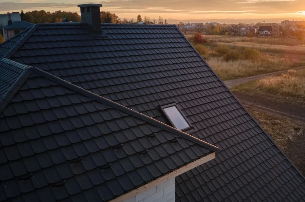 Dark tile roof with a skylight at sunset, showing a well-maintained home after a small roof issue repair