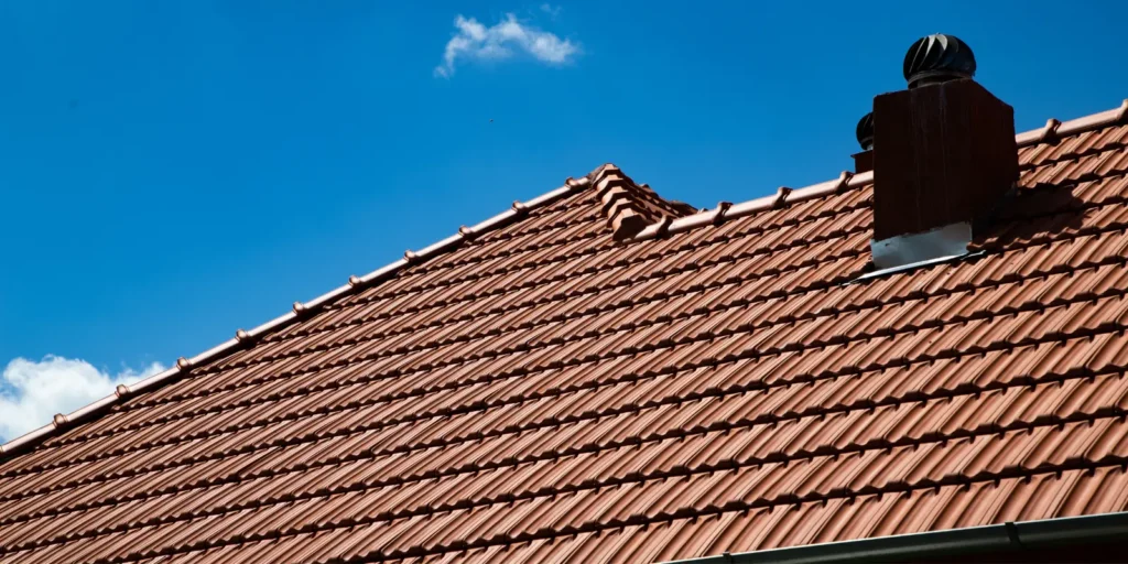 Clay tile roof with chimney and roof vents, highlighting areas that may need a small roof issue repair over time.