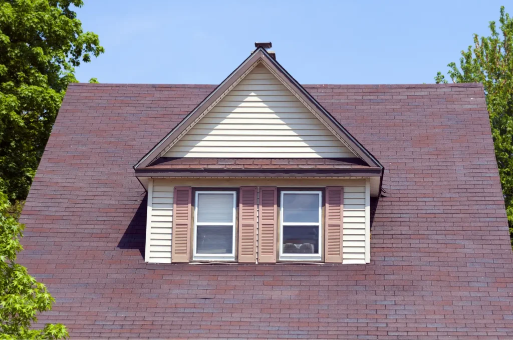 Front view of a residential roof with a dormer window, showing areas commonly reviewed during a roof inspection