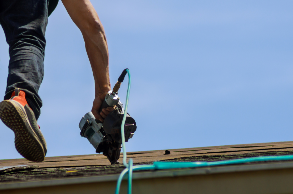 Roofer repairs damaged asphalt shingles and roof edges before leaks spread and urgent roof repairs become more serious soon. 