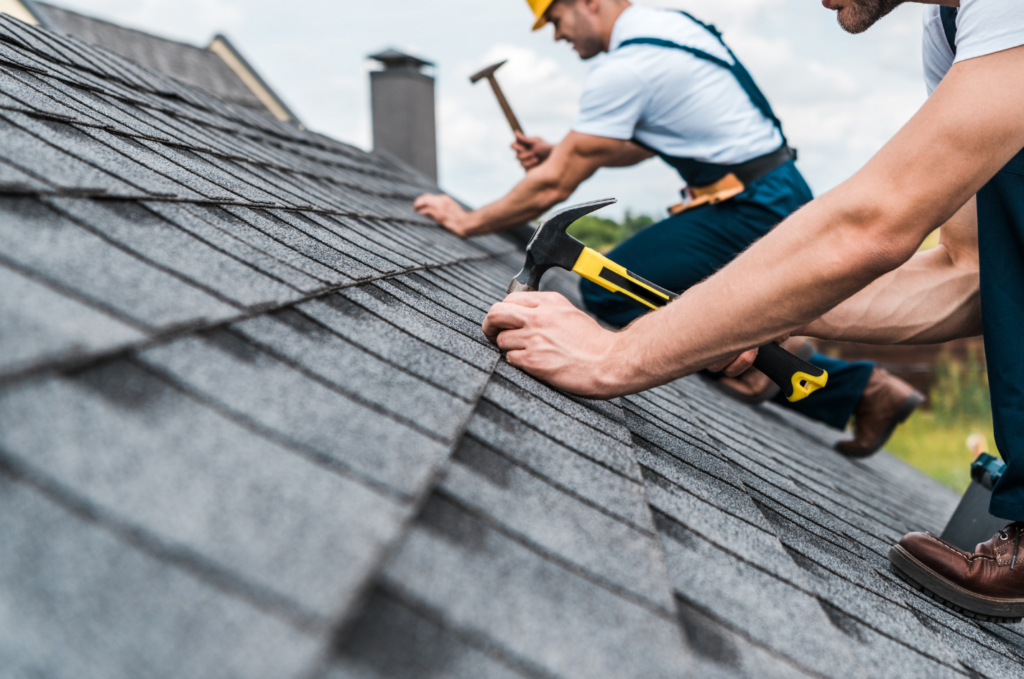 Roofers repair asphalt shingles during emergency roof repair service to check damage and protect the home after a roof leak. 