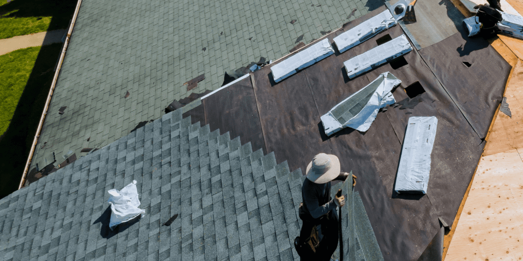 Aerial view of roofers preparing materials and roof sections before Boston roof installation work begins on a home project.