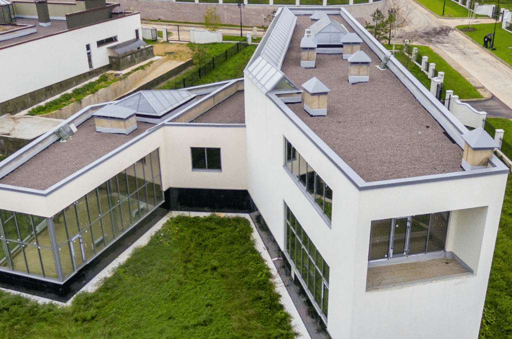 Aerial view of a flat roof with skylights, parapet walls, and metal edges where flat roof leaks often start for Boston owners
