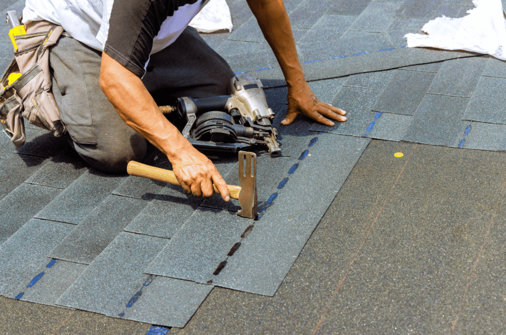 Roofer installs asphalt shingles during a professional roof installation project for a residential home in Boston.