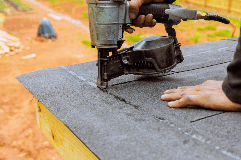 Roofer installs asphalt shingles during the early roof installation process for a residential home in Boston.
